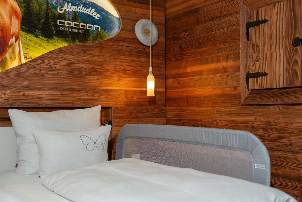 Small hotel room with a bed set against a panelled wall